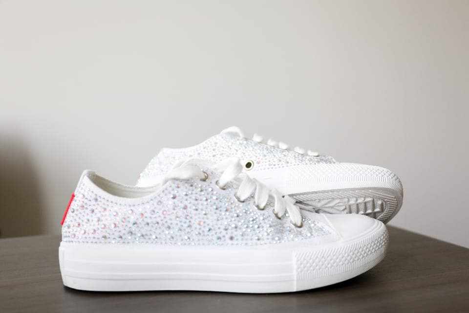 A pair of thin-soled casual sneakers on a city pavement