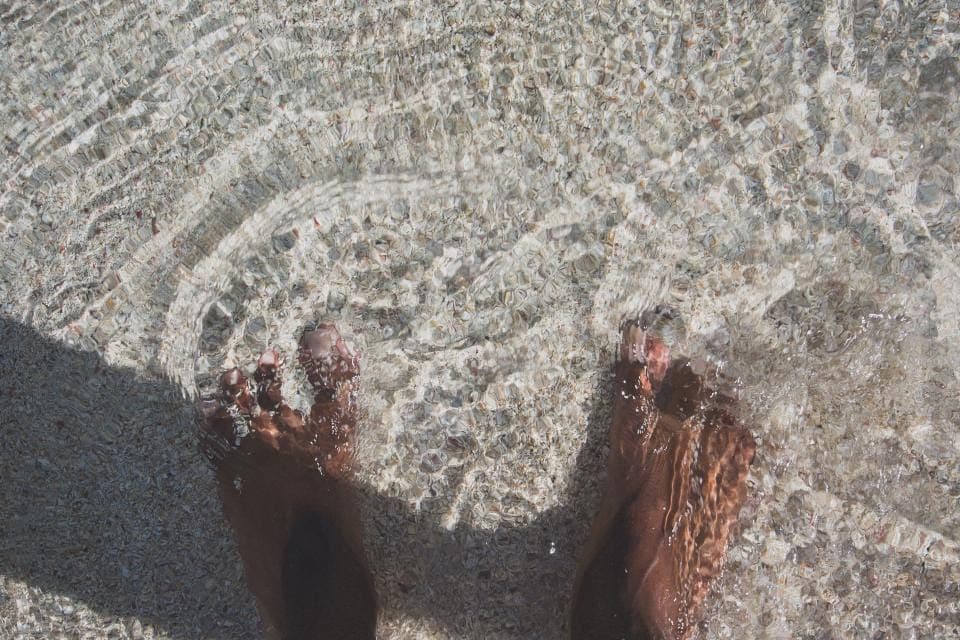 A bare foot measured against a ruler on a wooden floor